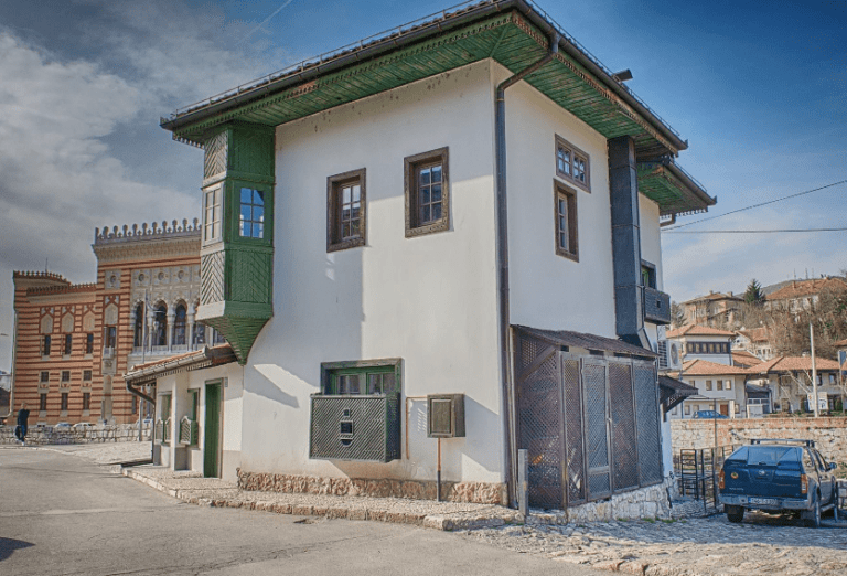 Spite house and a view of Sarajevo City Hall, which is on the other shore of Miljacka river.